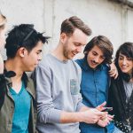 Group of five friends looking at a smartphone.