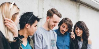 Group of five friends looking at a smartphone.