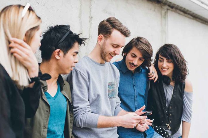 Group of five friends looking at a smartphone.