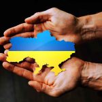 Hands holding Ukraine map with flag design.