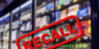 "Recall" stamp over blurred grocery store shelves.