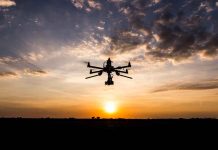 Drone flying against sunset sky.