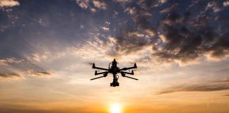 Drone flying against sunset sky.