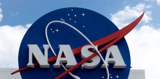 NASA logo on building exterior with cloudy sky.