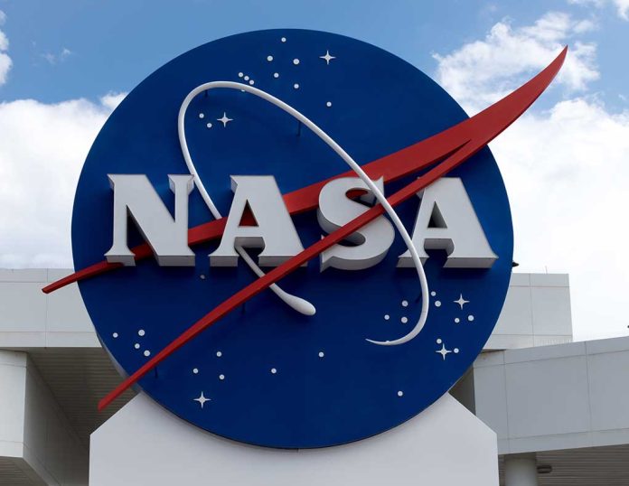 NASA logo on building exterior with cloudy sky.