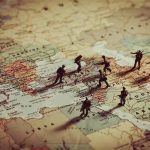 Toy soldiers on a world map background.