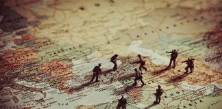 Toy soldiers on a world map background.