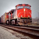 Red freight train on railroad tracks.