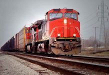 Red freight train on railroad tracks.