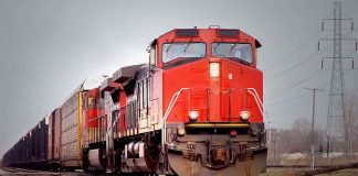 Red freight train on railroad tracks.