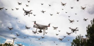 Many drones flying in a cloudy sky.