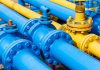 Blue and yellow industrial gas pipes with valves.