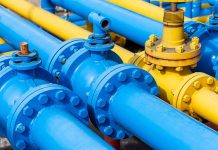 Blue and yellow industrial gas pipes with valves.