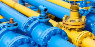 Blue and yellow industrial gas pipes with valves.