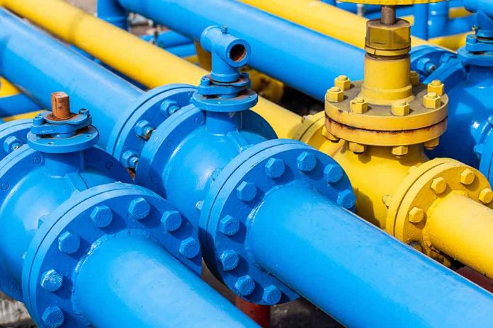 Blue and yellow industrial gas pipes with valves.