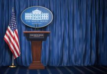 Empty White House podium and American flag.