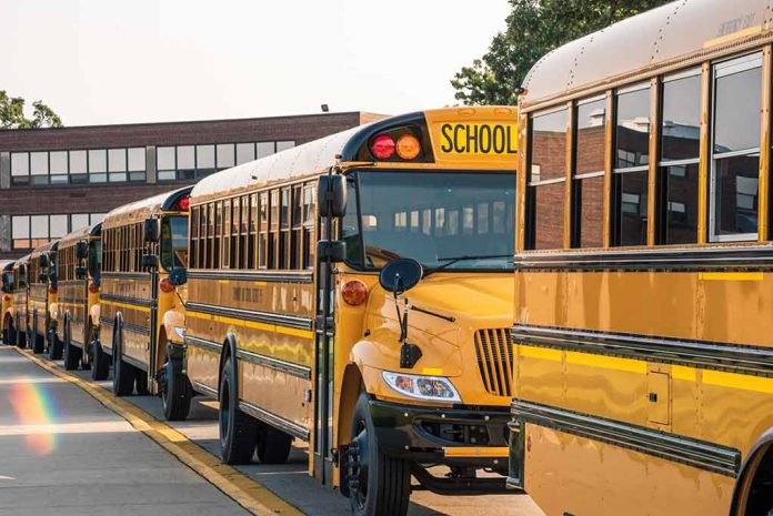 School buses lined up in front of building.