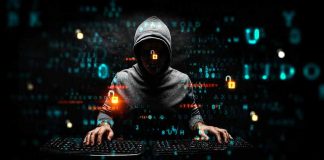 Hacker in hoodie using computer with digital code background.