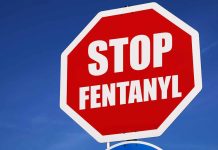 Stop sign saying "Stop Fentanyl" against sky.