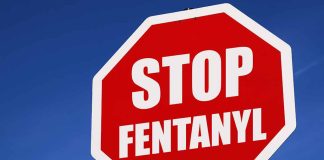 Stop sign saying "Stop Fentanyl" against sky.