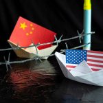 China and USA flags in paper boats with barbed wire.