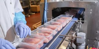 Packaged chicken breasts on a factory conveyor belt.