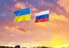 Ukrainian and Russian flags against vibrant sunset sky