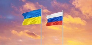 Ukrainian and Russian flags against vibrant sunset sky