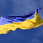 Ukrainian flag waving against a blue sky.