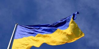 Ukrainian flag waving against a blue sky.