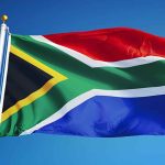 South African flag waving against blue sky.