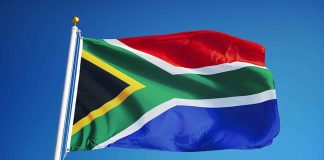 South African flag waving against blue sky.