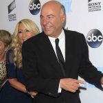 members of the Shark Tank cast in front of a wall at an ABC media event