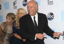 members of the Shark Tank cast in front of a wall at an ABC media event