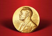 Gold Nobel Prize medal on red background.