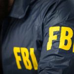 Person wearing FBI jacket with yellow lettering