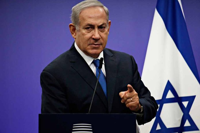 Prime minister Benjamin Netanyahu pointing to the camera in front of Israeli flag