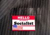 "Hello my name is Socialist" name tag on suit.