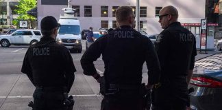 Three police officers standing on a city street.