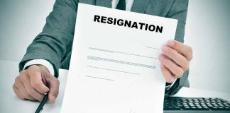 Person holding resignation letter at desk