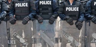 Police officers with riot gear and shields.