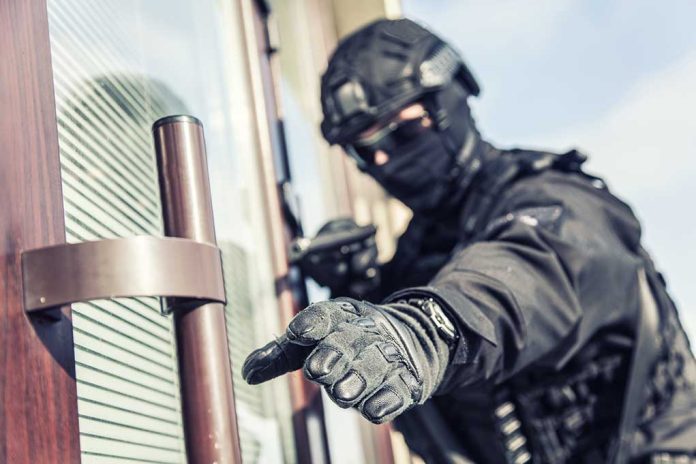 SWAT officer reaching for door handle.