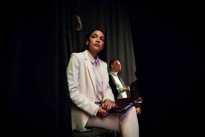 Person in white suit sitting backstage with clipboard