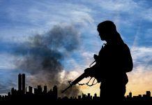 Silhouette of armed person with cityscape background smoke