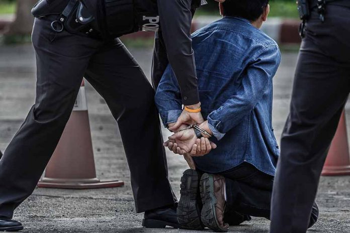 Police arresting person kneeling on pavement