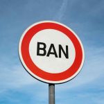 Sign with BAN against blue sky.