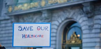 Sign reading Save Our Healthcare at protest.