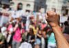 Raised fist in front of a crowd.