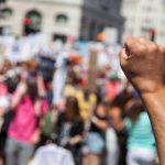 Raised fist in front of a crowd.