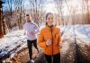 Two people jogging on a snowy path outdoors